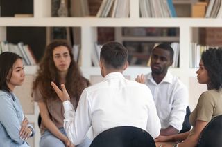 Menschen sitzen im Kreis und diskutieren